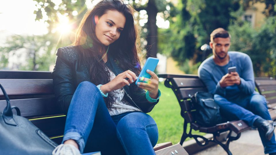 Un homme et une femme tapent sur leur téléphone portable